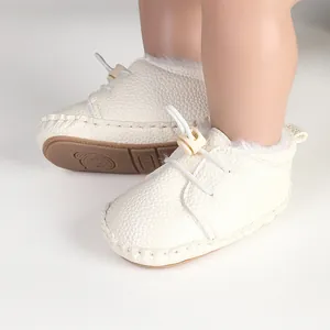 Detailaufnahme weißer Babyschuhe aus genarbtem Leder mit Kordelzug und warmem Fleecefutter