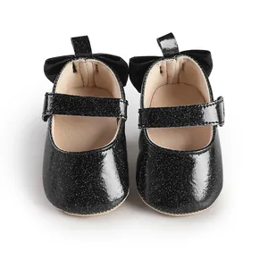 Close-up detail of black glitter baby Mary Jane shoes with elegant velvet heel bows