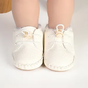 Nahaufnahme weißer gefütterter Lauflernschuhe für Babys mit verstellbarem Gummizug