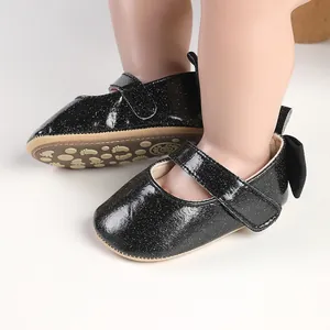 Macro view of sparkly black baby girl Mary Jane pre-walker shoes with a cute bow