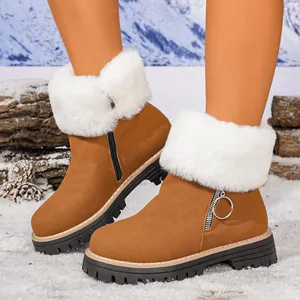 Brown suede snow boots with white faux fur collar and side zipper in a snowy scene