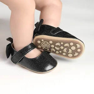 Close-up of glittery black baby girl pre-walker shoes with bow and velcro strap