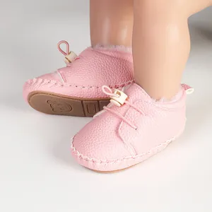 Nahaufnahme von rosa Leder-Lauflernschuhen für Babys mit warmem Plüschfutter für den Winter