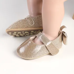 Detail view of champagne golden glitter baby girl pre-walking shoes with bow back