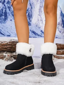 Detail view of black women's snow boots featuring white faux fur and side zipper