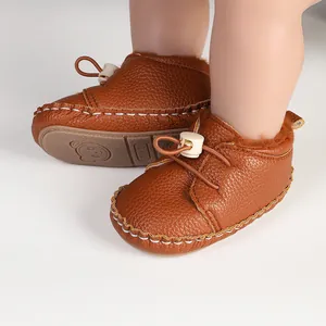 Nahaufnahme brauner, fleecegefütterter Baby-Lauflernschuhe mit weicher Gummisohle.