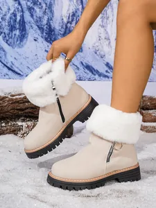 Beige winter snow boots with white faux fur trim and platform soles in snow setting.