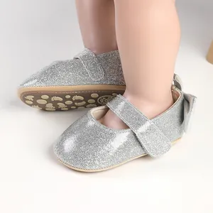Close-up of silver glitter baby Mary Jane shoes with bow detail and soft anti-slip sole.