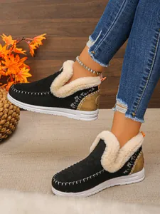 Détail de bottes de neige noires avec doublure en polaire blanche épaisse et surpiqûres