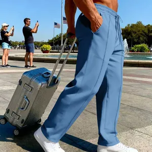 Detailansicht der blauen Herrenhose mit Kordelzug in einer Reiseszene im Freien.