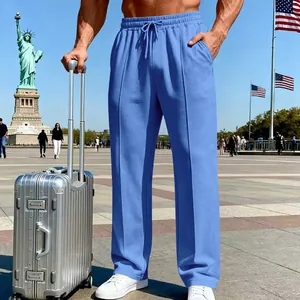 Blaue lässige Herrenhose mit geradem Bein in Reiseszene mit Koffer und Wahrzeichen