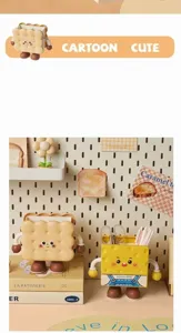 Close-up of cute cartoon biscuit and cheese shaped desktop pen holders in a cozy setting