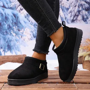 Close-up of women's black snow boots featuring a stylish metal buckle and fur lining