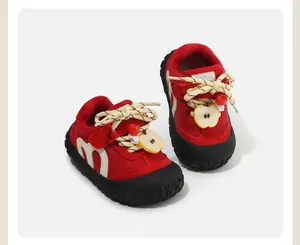 Close-up of red toddler winter sneakers with cute apple charm and warm plush lining