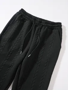 Dettaglio ravvicinato di pantaloni neri da uomo in maglia a trecce con coulisse in vita