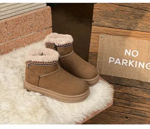 Close-up of brown women's snow boots with ethnic embroidery, plush lining, and thick sole