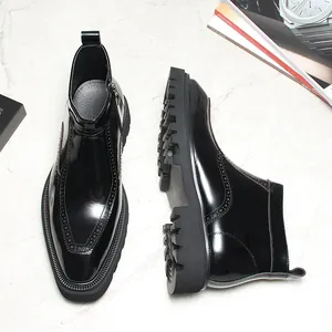 Détail de bottines Chelsea en cuir verni noir avec perforations et semelle crantée