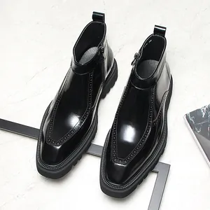 Gros plan de bottines Chelsea en cuir noir de qualité avec détails brogues et bout pointu élégant.