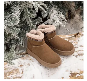 Detailed side view of brown platform snow boots with ethnic embroidery in a snowy scene