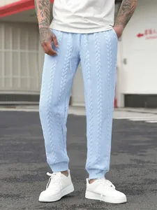 Dettaglio dei pantaloni joggers azzurri da uomo con trama a trecce e laccio in vita