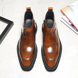 Détail de bottines Chelsea en cuir marron avec perforations richelieu et fermeture éclair.