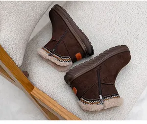 Detailed side view of brown women's snow boots featuring ethnic embroidery and a thick sole