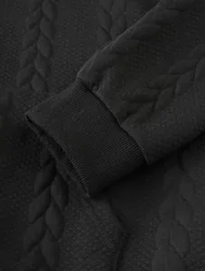 Macro view of black ribbed cuff and embossed cable-knit texture on men's hoodie