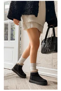 Close-up detail of women's black platform snow boots with ethnic embroidery and fur lining
