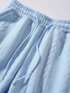Dettaglio del tessuto in maglia strutturata azzurro e coulisse sui pantaloni sportivi uomo
