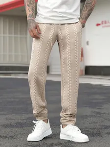 Primo piano dei joggers da uomo beige in maglia a trecce in un ambiente urbano