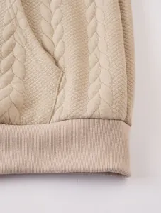 Detailed close-up showing beige cable knit and quilted fabric on men's hoodie hem