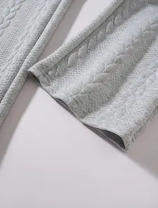 Dettaglio macro del tessuto grigio trapuntato e del fondo gamba dritto dei pantaloni da uomo.