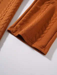 Dettaglio ravvicinato della trama a maglia a trecce e dell'orlo dei pantaloni uomo.