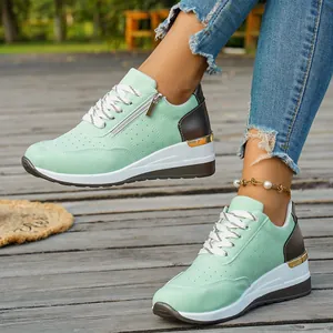 Close-up detail of women's mint green color-block platform sneakers with side zipper