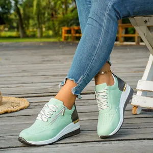 Close-up view of mint green platform sneakers with side zipper and lace-up design