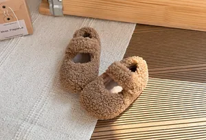 Primo piano di scarpe in pile Sherpa marrone per bambini con cinturino invernale accogliente