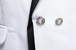 Detail of white slim fit suit jacket with elegant rhinestone buttons and black lapel