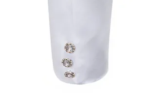 Macro detail shot of a white business suit sleeve featuring three decorative crystal buttons.