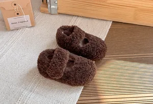 Primo piano di calde scarpine in peluche marrone per neonati in inverno