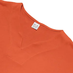 Detail view of orange V-neck t-shirt showing the care label and fabric texture.
