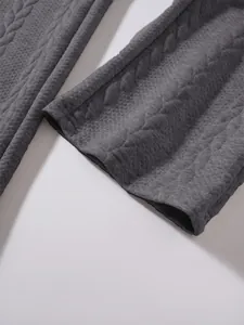 Dettaglio del tessuto grigio strutturato e dell'orlo dritto dei pantaloni casual da uomo