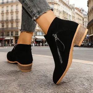 Stylish black suede ankle boots with double side zippers and chunky heel on city street