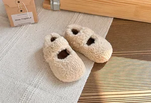 Dettaglio di scarpe in peluche beige per bambini con calda fodera in pile invernale