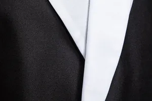 Close-up of men's slim fit suit jacket showing contrast lapel and fine fabric texture