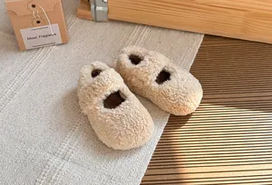Vista dettagliata della morbida texture in peluche color crema delle scarpe invernali Mary Jane per bambini.