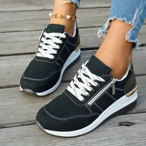 Detailed view of women's black and white chunky sneakers with gold metallic heel trim