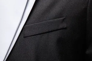 Close-up detail of the chest pocket and premium black twill fabric on a men's business blazer