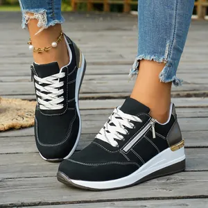 Detailed view of stylish black and white women's sneakers worn on a wooden boardwalk