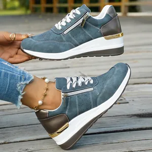 Close-up of women's blue suede wedge sneakers with side zipper and gold trim