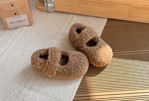 Primo piano di scarpe Mary Jane in pile marrone per bambini su un tappeto materico